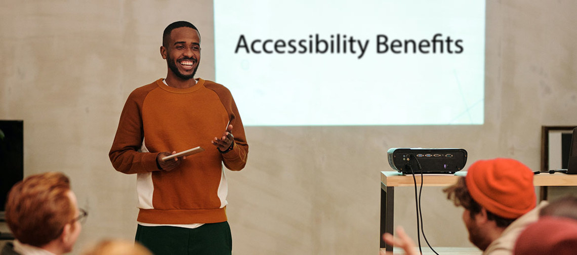 smiling man presenting Accessibility Benefits to a team