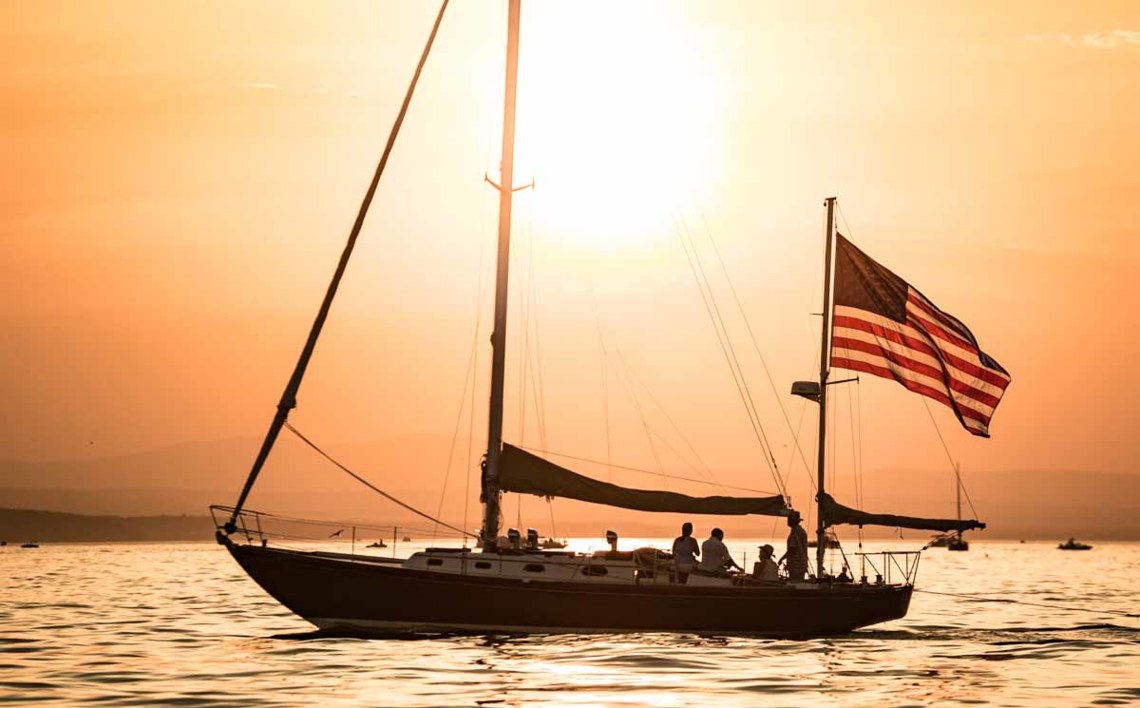 sailboat with flag with bright orange sunset - metaphor for website remediation